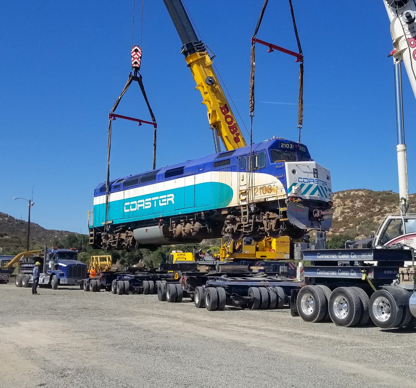 SDNX 2103 is craned off two large highway dollies at Campo SDNX 2103 is craned off two large highway dollies at Campo. Photo by Stephen Hager.