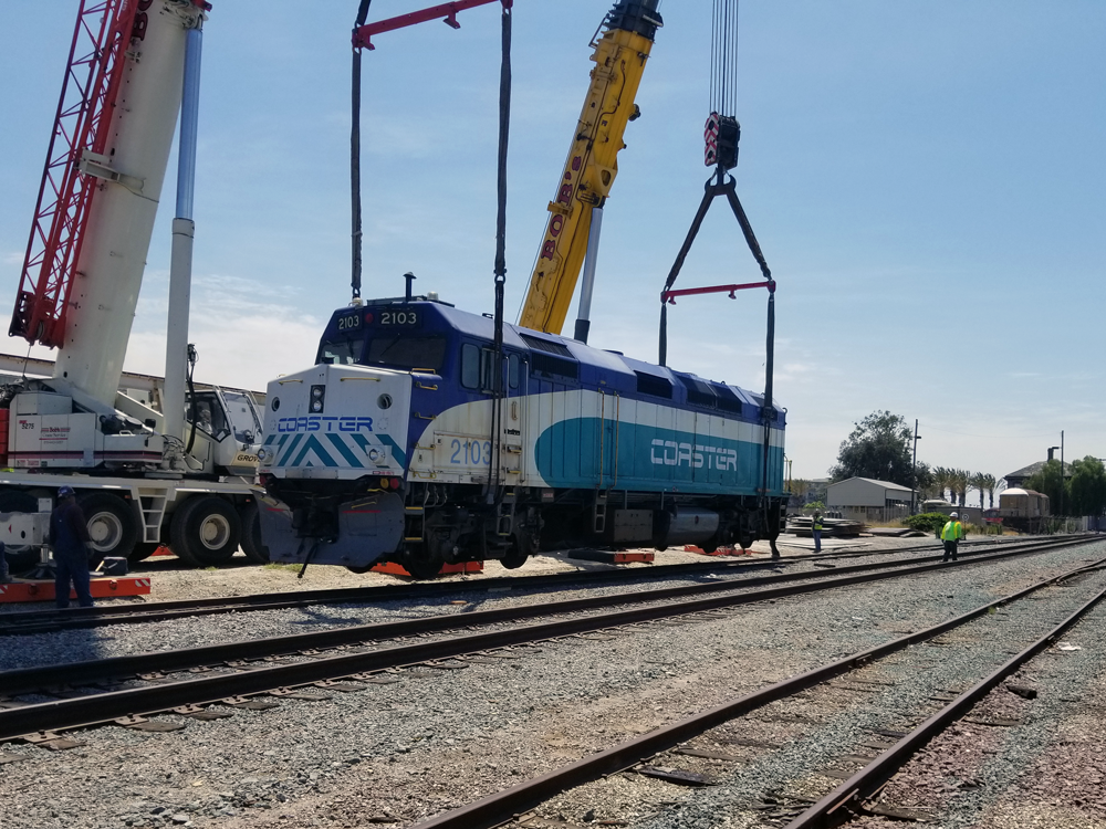 Coaster 2103 NS_Lift SDNX 2103 is lifted off the rails for the first time in National City, CA to be transferred to specialized dollies for the trip by road to Campo.